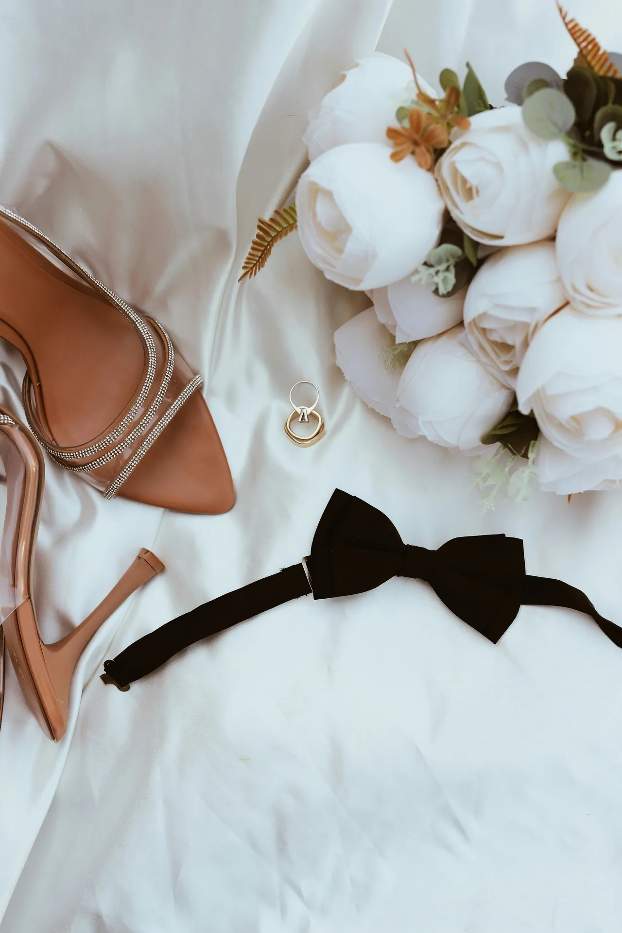 Styled Flatlay mit Brautschuhen, Eheringen und Fliege